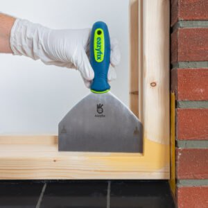 Met het Reparatiemes groot wordt de Houtrotvuller afgestreken om ervoor te zorgen dat er een strakke hoek komt in het kozijn.